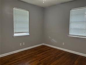 spare room featuring ceiling fan and dark wood-type flooring