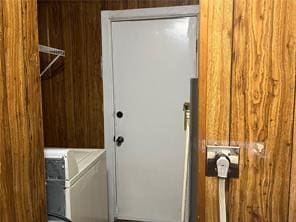 laundry area with wood walls