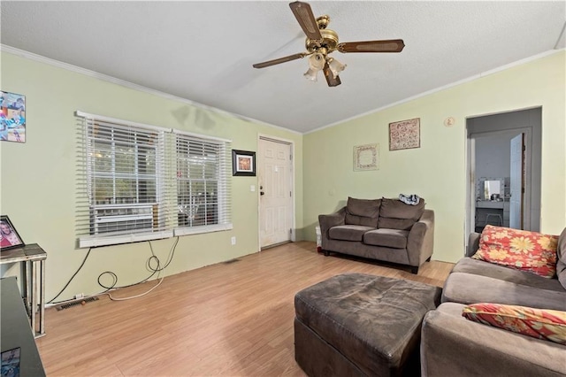 living room featuring ornamental molding, vaulted ceiling, ceiling fan, and light wood-type flooring