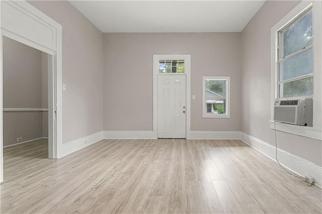 empty room featuring cooling unit and light hardwood / wood-style flooring