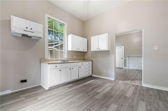 kitchen featuring sink, white cabinets, and light hardwood / wood-style flooring