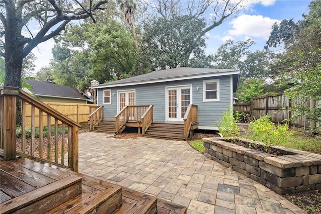 rear view of property with a deck, french doors, and a patio area