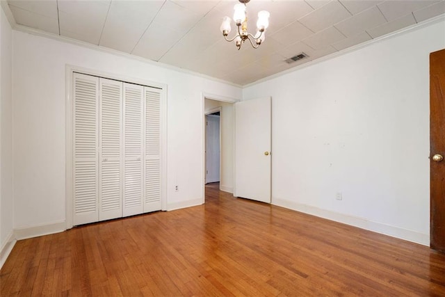 5405 Dogwood Ct, Mobile, AL 36693 - unfurnished bedroom with ornamental molding, a chandelier, light wood-style flooring, baseboards, and a closet