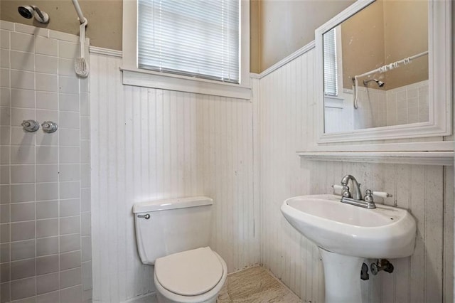 5405 Dogwood Ct, Mobile, AL 36693 - bathroom featuring a tile shower, toilet, and wainscoting