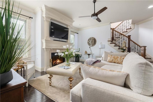 living room with ornamental molding, wood-type flooring, and ceiling fan