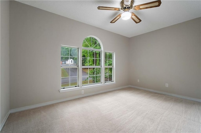 empty room featuring baseboards, ceiling fan, carpet flooring, and a textured ceiling
