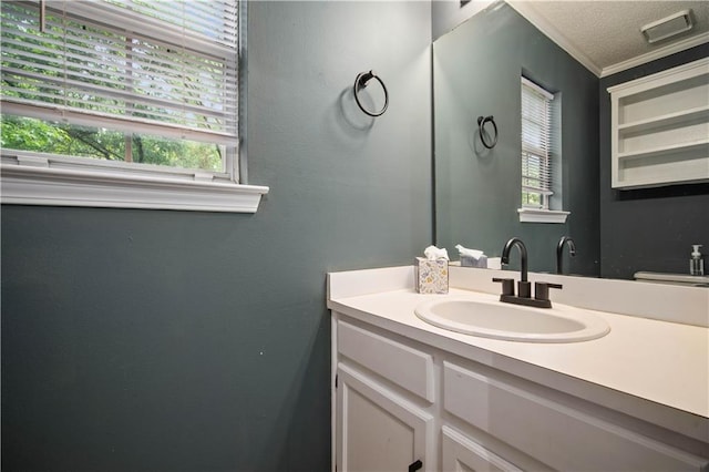 bathroom featuring crown molding, visible vents, and vanity