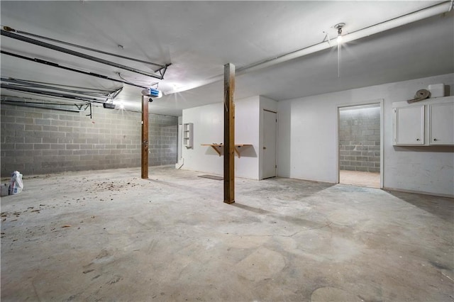 basement with concrete block wall and a garage