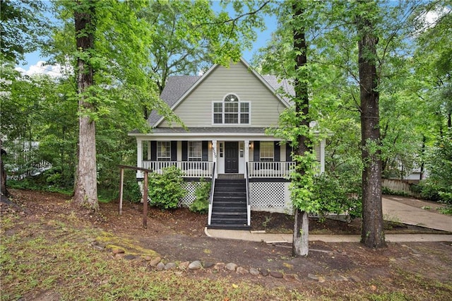 view of front of property with covered porch, a shingled roof, and stairway