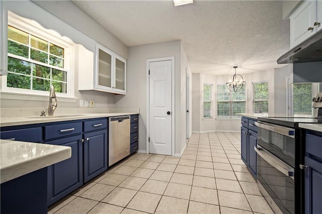 kitchen featuring under cabinet range hood, blue cabinets, a sink, appliances with stainless steel finishes, and a notable chandelier