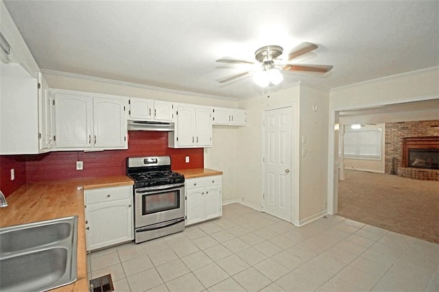 kitchen with white cabinets, ceiling fan, stainless steel range with gas stovetop, and sink