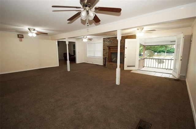 interior space with dark carpet, ceiling fan, beam ceiling, a brick fireplace, and crown molding