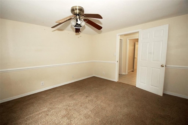 carpeted spare room featuring ceiling fan