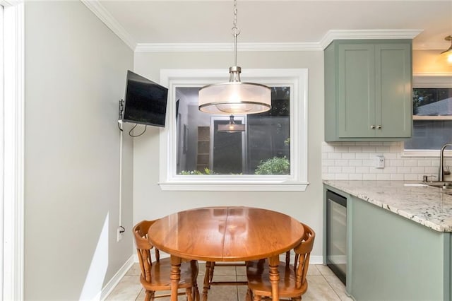 tiled dining area with ornamental molding, sink, and beverage cooler