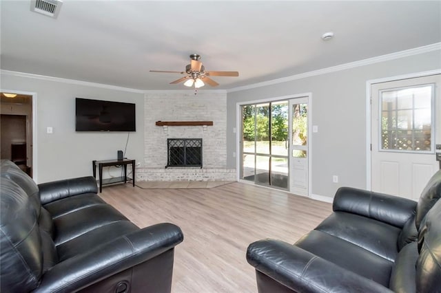 living room featuring light hardwood / wood-style floors, a stone fireplace, ornamental molding, and ceiling fan