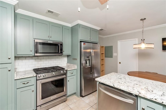 kitchen featuring crown molding, green cabinetry, pendant lighting, light tile patterned floors, and appliances with stainless steel finishes