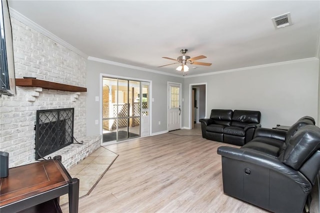 living room featuring a fireplace, light wood-type flooring, and crown molding