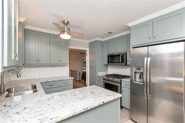 kitchen with backsplash, appliances with stainless steel finishes, ceiling fan, crown molding, and sink