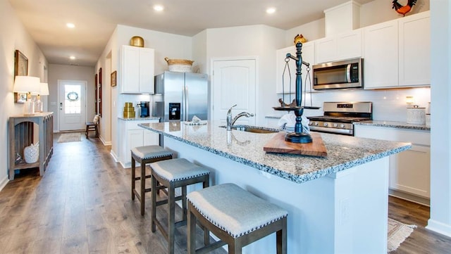 7327 Hawkins Mnr N, Mobile, AL 36695 - kitchen with appliances with stainless steel finishes, a breakfast bar, tasteful backsplash, a center island with sink, and recessed lighting