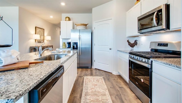 7327 Hawkins Mnr N, Mobile, AL 36695 - kitchen featuring stainless steel appliances, light wood finished floors, recessed lighting, white cabinets, and light stone countertops