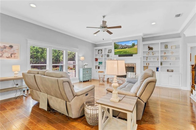 8662 Daintree Ct, Daphne, AL 36526 - living area with a brick fireplace, a ceiling fan, ornamental molding, wood-type flooring, and recessed lighting
