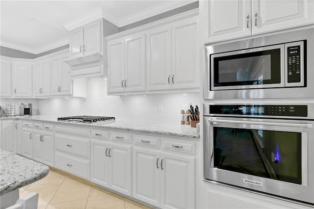 8662 Daintree Ct, Daphne, AL 36526 - kitchen with stainless steel appliances, white cabinets, ornamental molding, backsplash, and light tile patterned flooring