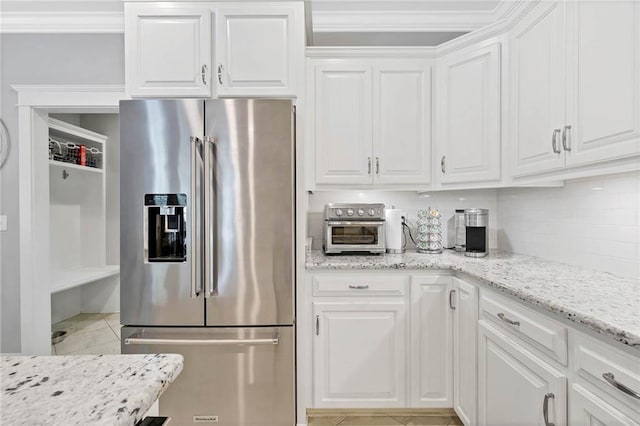 8662 Daintree Ct, Daphne, AL 36526 - kitchen with stainless steel fridge with ice dispenser, white cabinetry, decorative backsplash, light tile patterned floors, and light stone countertops