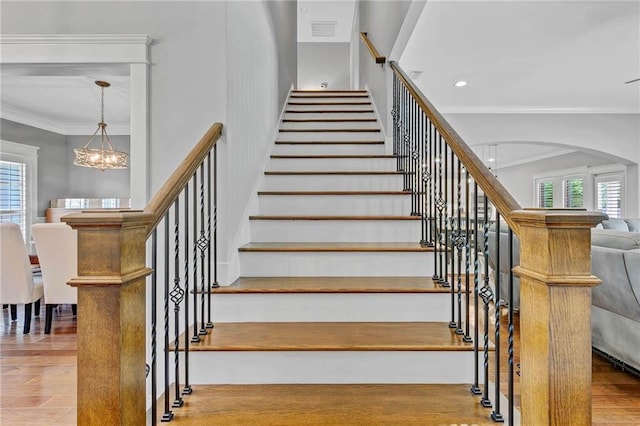 8662 Daintree Ct, Daphne, AL 36526 - stairs with ornamental molding, a chandelier, arched walkways, wood finished floors, and recessed lighting