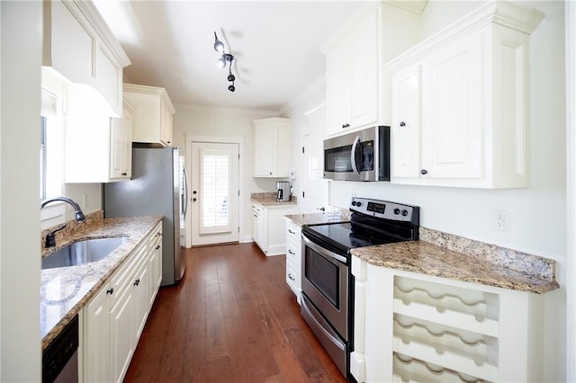 kitchen with light stone countertops, dark wood-style flooring, a sink, white cabinets, and appliances with stainless steel finishes