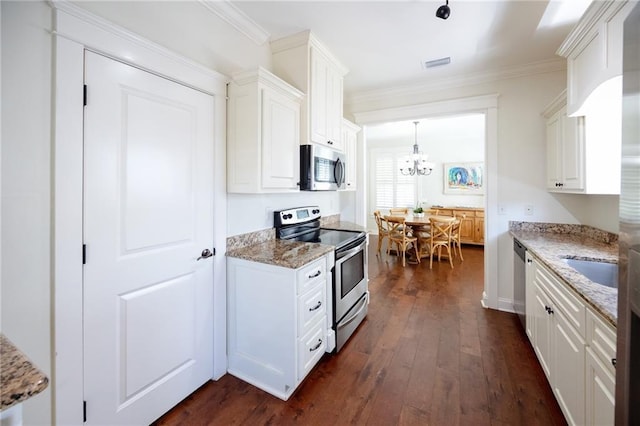 kitchen with appliances with stainless steel finishes, a chandelier, dark wood-style flooring, and light stone countertops