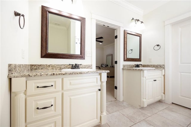 bathroom featuring a sink, ceiling fan, ornamental molding, and two vanities