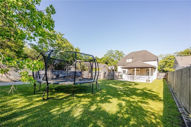 view of yard featuring a trampoline and a fenced backyard