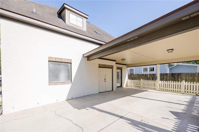 view of patio / terrace with fence and a carport
