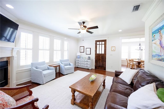 living area featuring ceiling fan, a fireplace, visible vents, and plenty of natural light