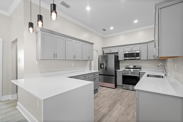 kitchen with visible vents, gray cabinets, a sink, appliances with stainless steel finishes, and crown molding