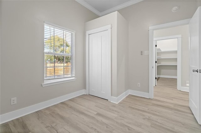 unfurnished bedroom with light wood-type flooring, baseboards, a closet, and ornamental molding