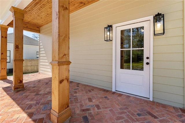 property entrance with fence and a patio area