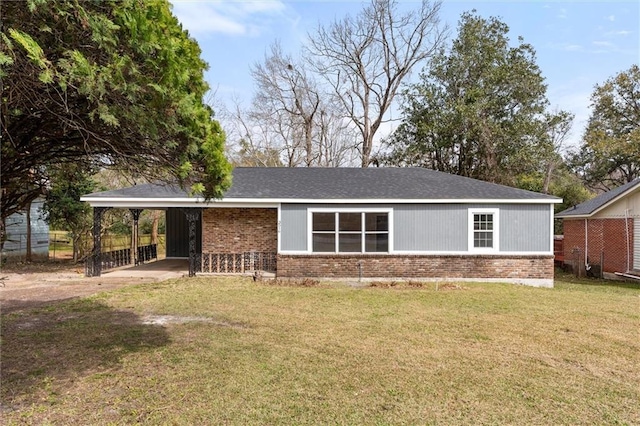 view of front facade with a carport, brick siding, fence, and a front lawn