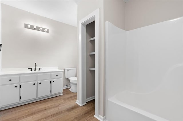 full bathroom with vanity, wood finished floors, toilet, and baseboards