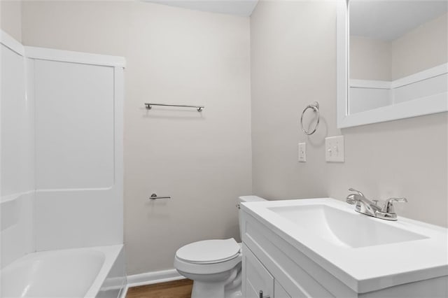 bathroom with toilet, baseboards, wood finished floors, and vanity