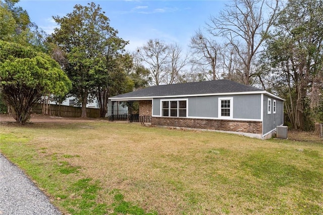 ranch-style home featuring brick siding, a front yard, fence, and central air condition unit