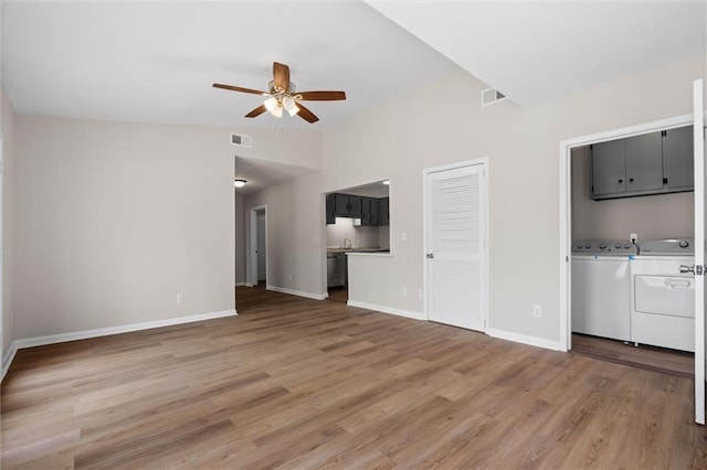 unfurnished living room with a ceiling fan, visible vents, light wood-style flooring, and separate washer and dryer