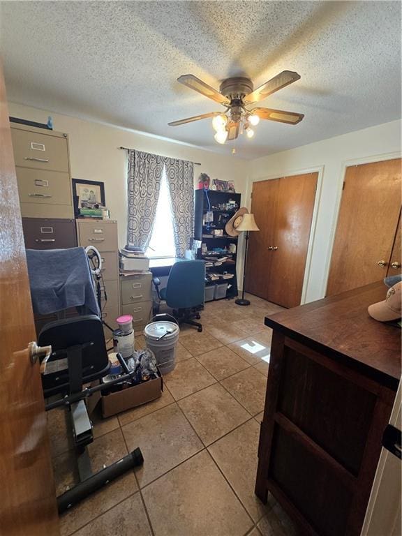 tiled office with ceiling fan and a textured ceiling