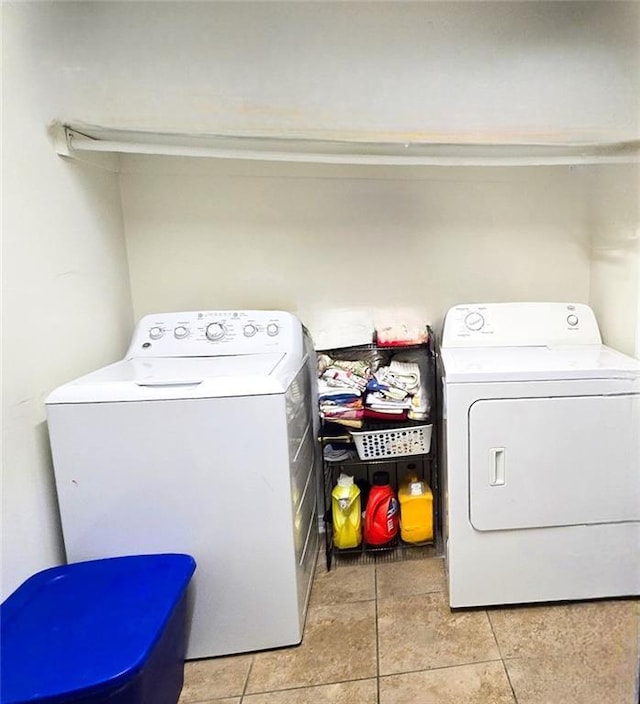 laundry area featuring washing machine and dryer and light tile patterned flooring