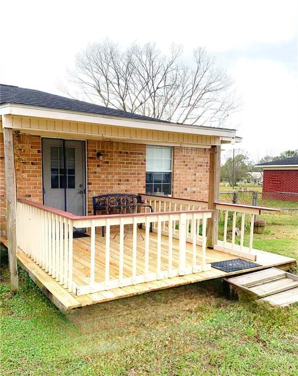 wooden deck featuring a lawn