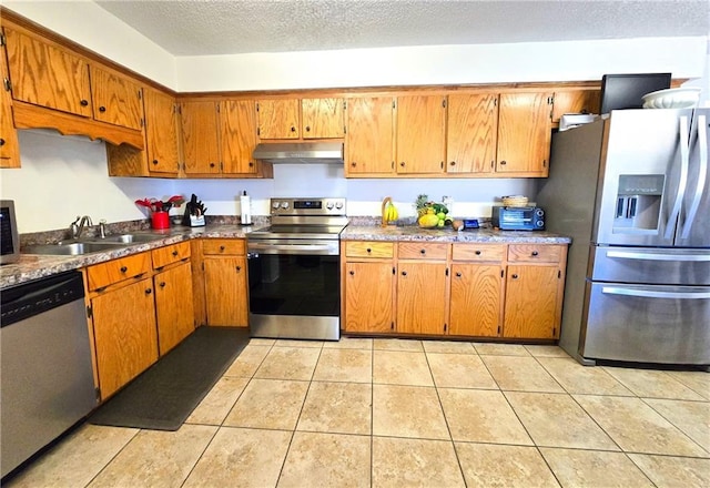 kitchen featuring sink, a textured ceiling, light tile patterned floors, and appliances with stainless steel finishes