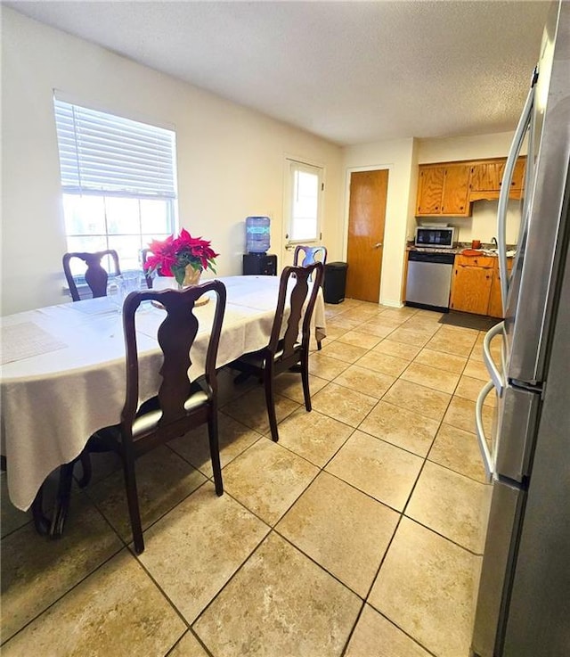 dining room featuring a textured ceiling and light tile patterned floors