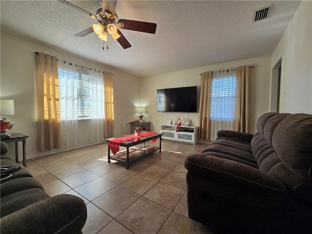 tiled living room with a textured ceiling and ceiling fan