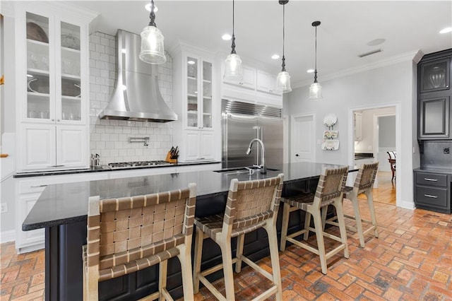 kitchen with stainless steel appliances, a spacious island, backsplash, and wall chimney exhaust hood