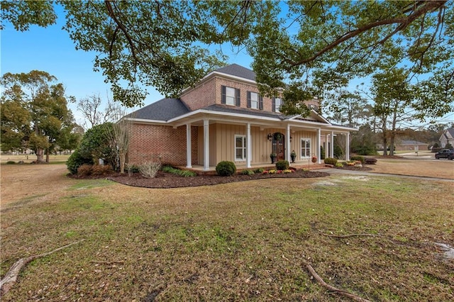 country-style home featuring a porch and a front yard